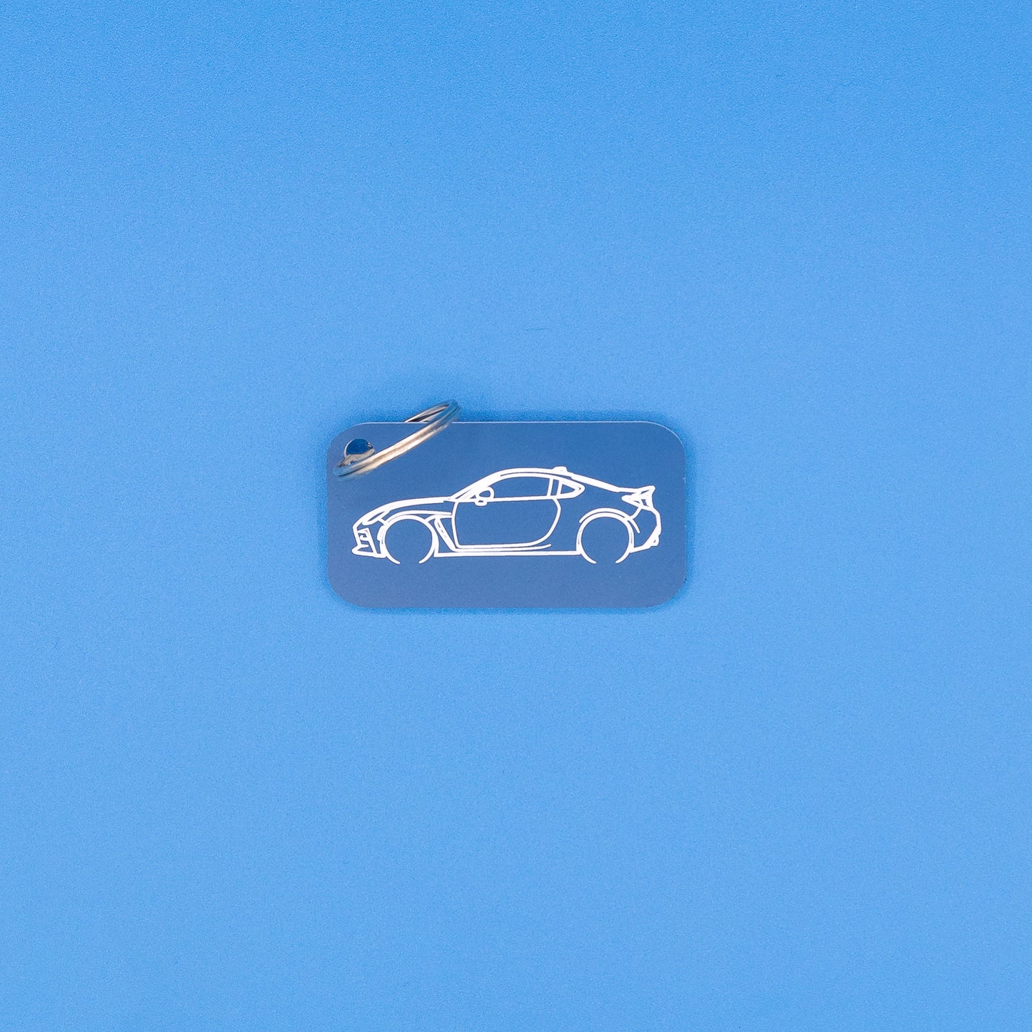 Toyota GR86 Keychain with classic key ring on blue background