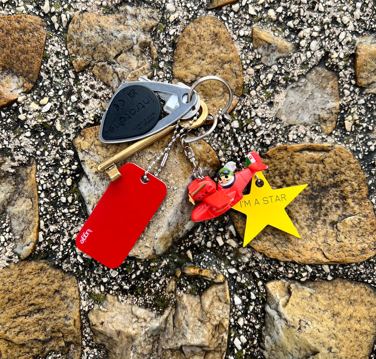 Keychain with various accessories including a luggie star design acrylic keychain in yellow.