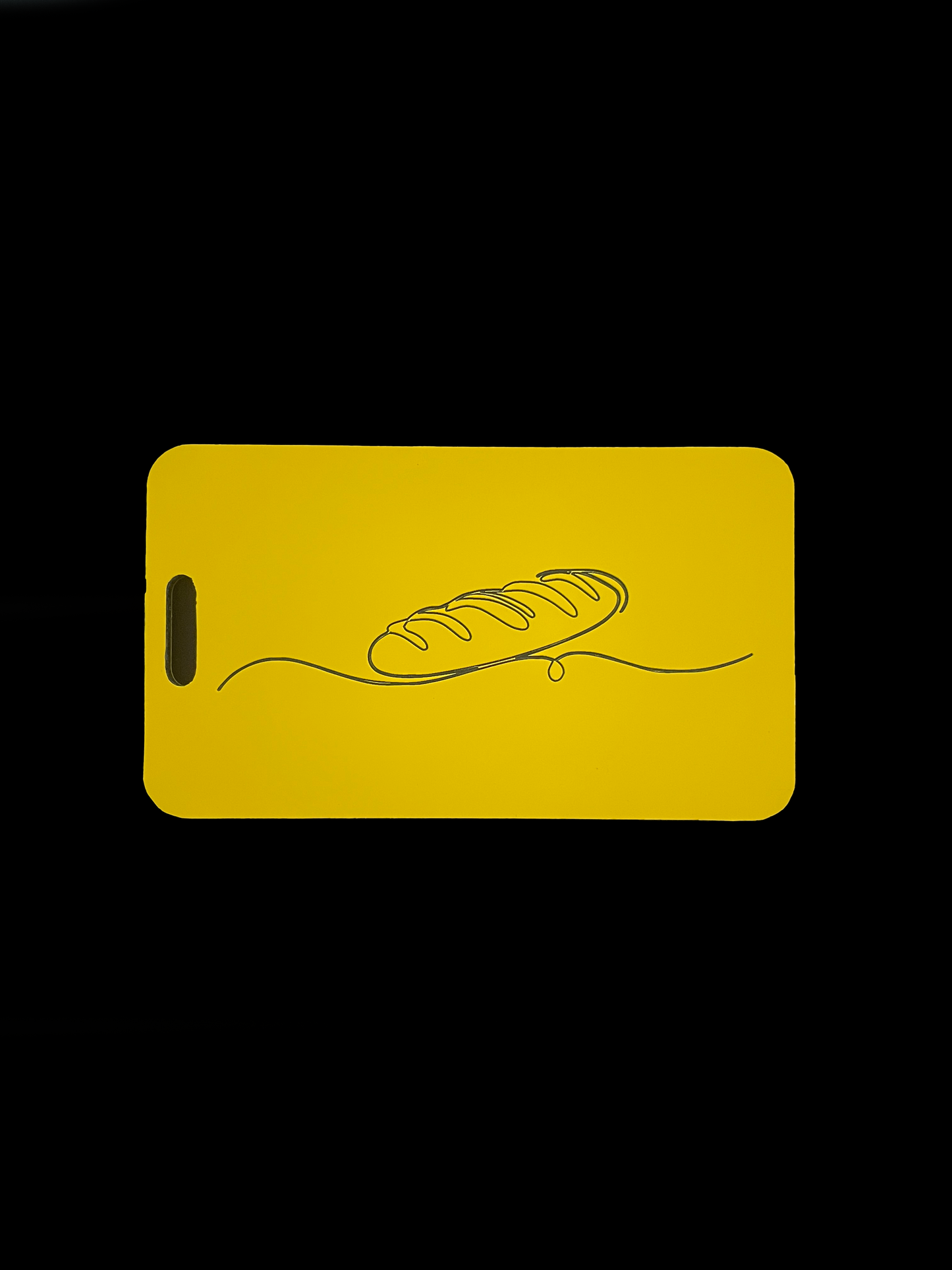 Yellow luggage tag with a bread design on a black background