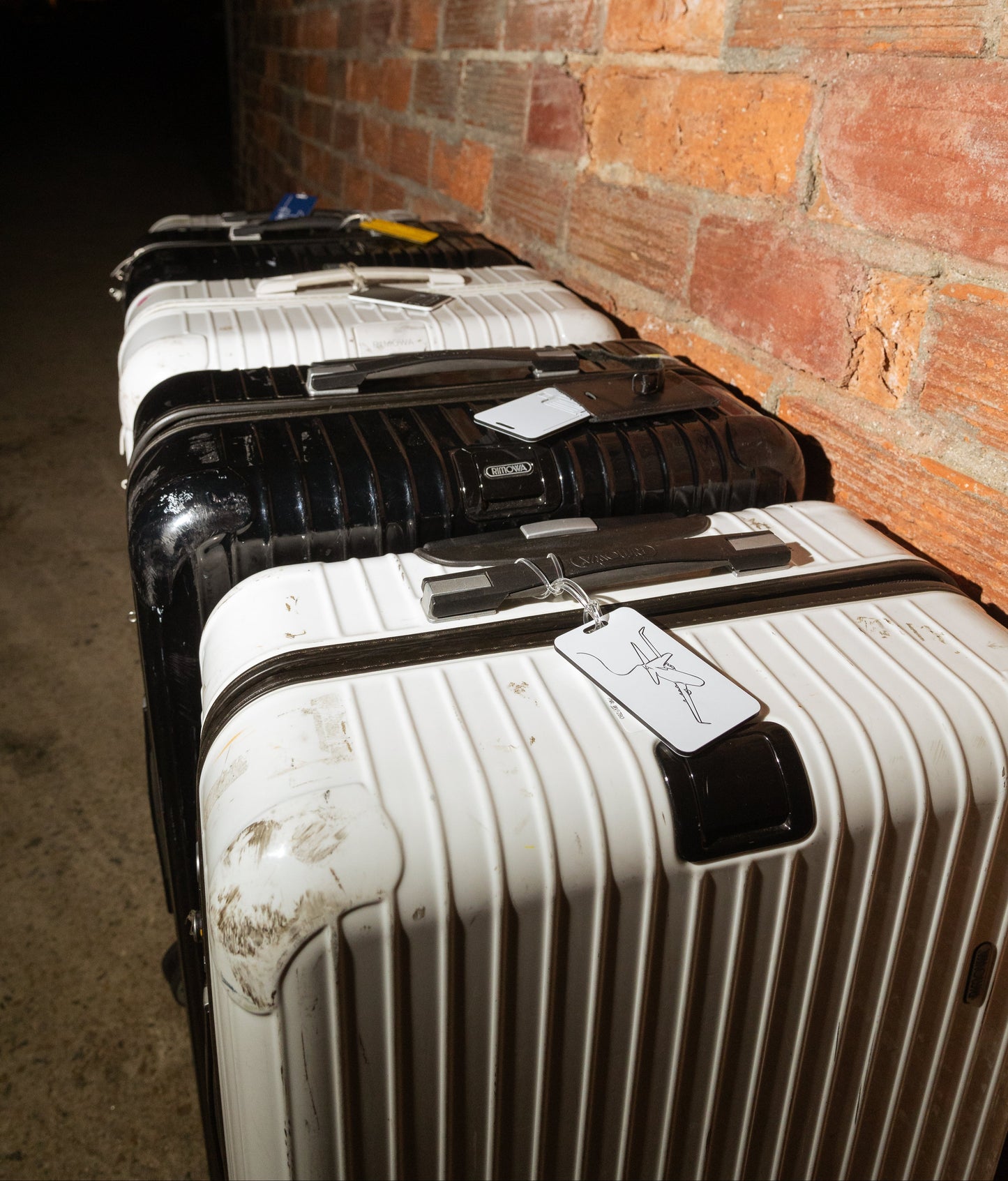 Voyage Luggage Tag in white attached to Rimowa suitcase.