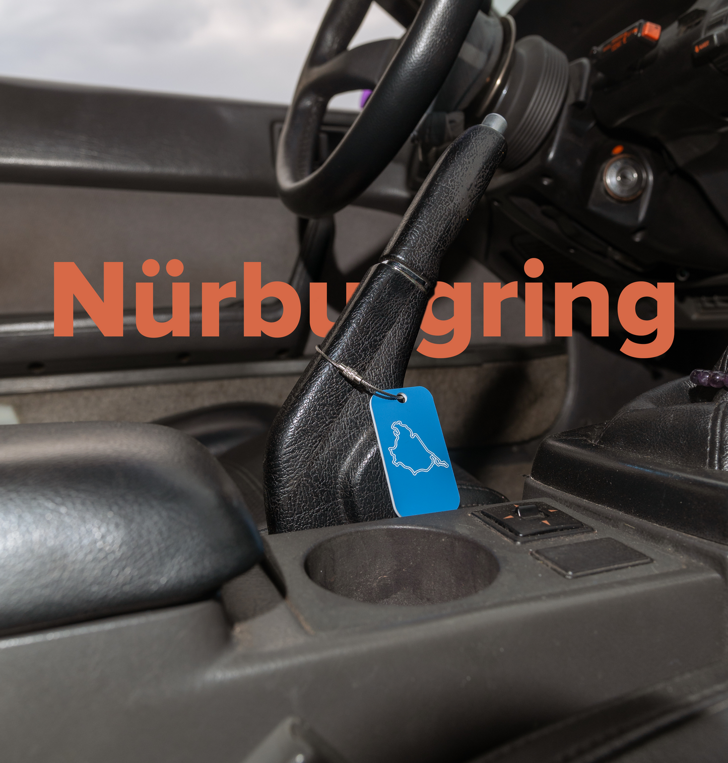 Photo of Nürburgring Acrylic Keychain in light blue inside an FC RX7.