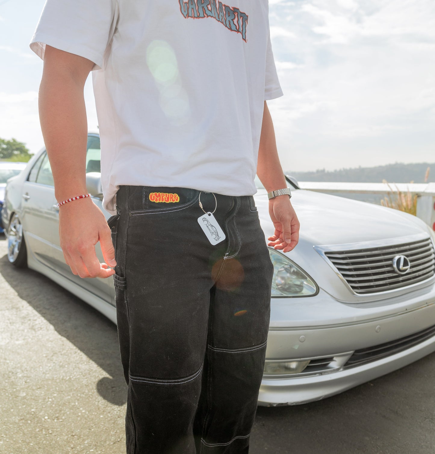 Picture of Supra Acrylic Keychain in white attached to belt strap with wire loop.