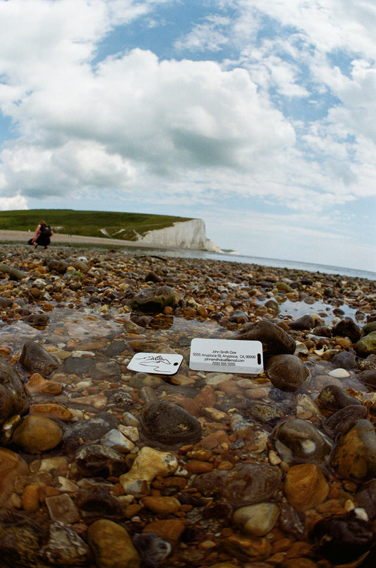 Wide Angle 35mm film photo of summit keychain and luggage tag in white.