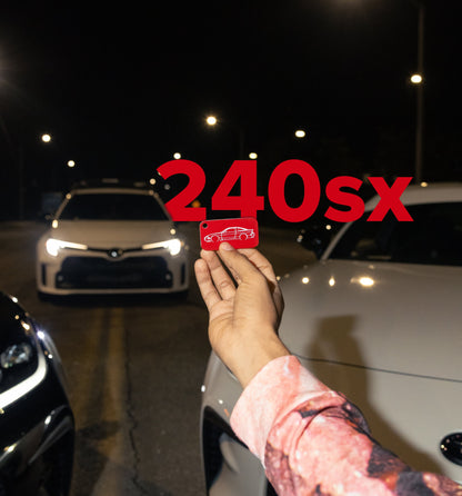 Nissan 240sx Keychain being held in front of JDM cars. 