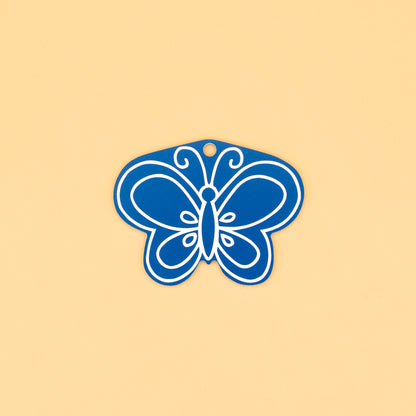 Blue butterfly-shaped keychain on a beige background