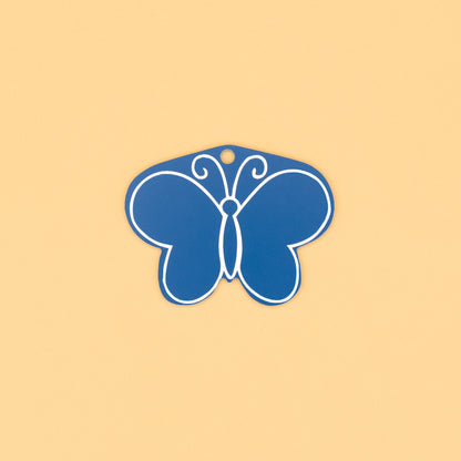 Rear of butterfly-shaped keychain on a beige background