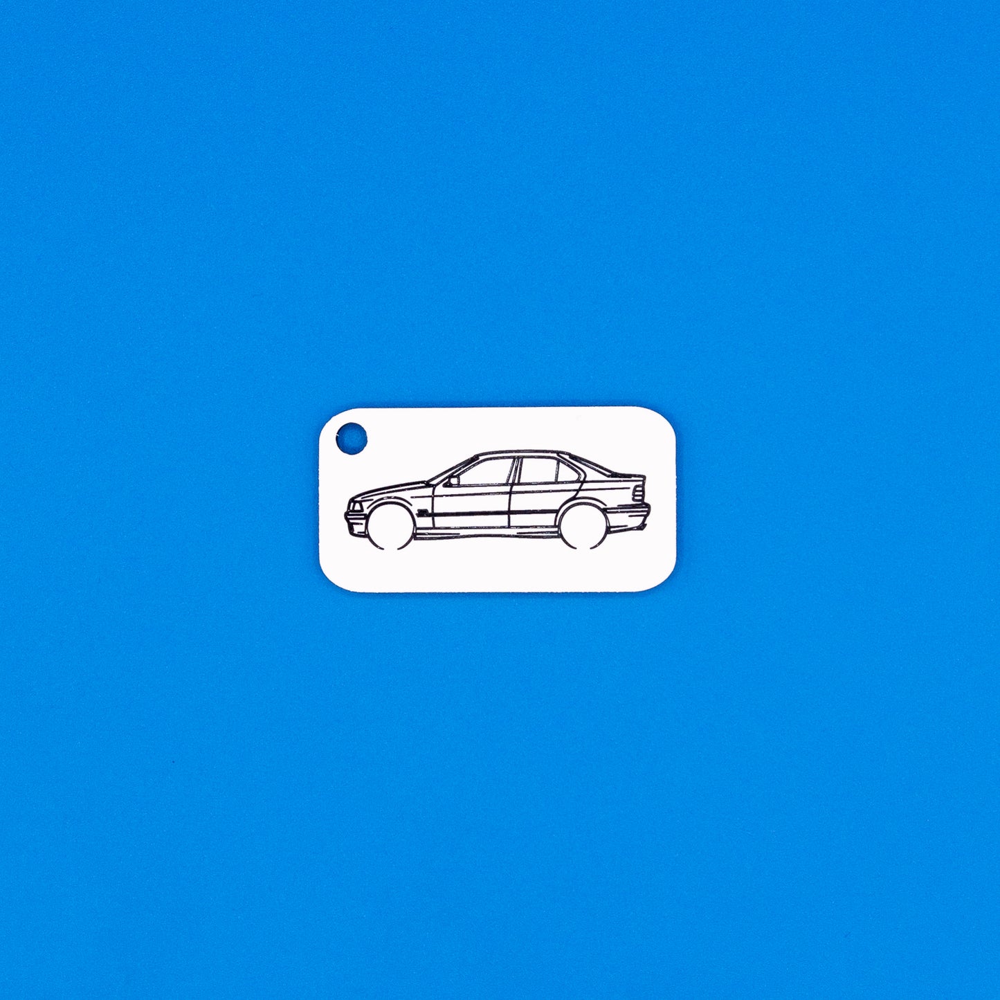 acrylic keychain with BMW e36 sedan design on a blue background