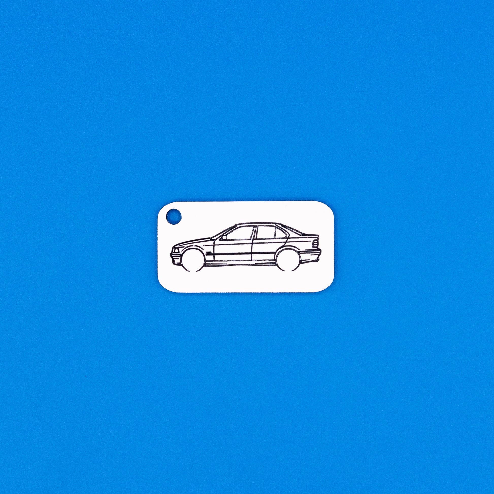 acrylic keychain with BMW e36 sedan design on a blue background