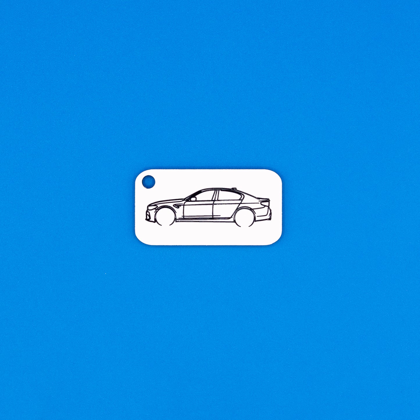 BMW F90 M5 keychain in white on a blue background