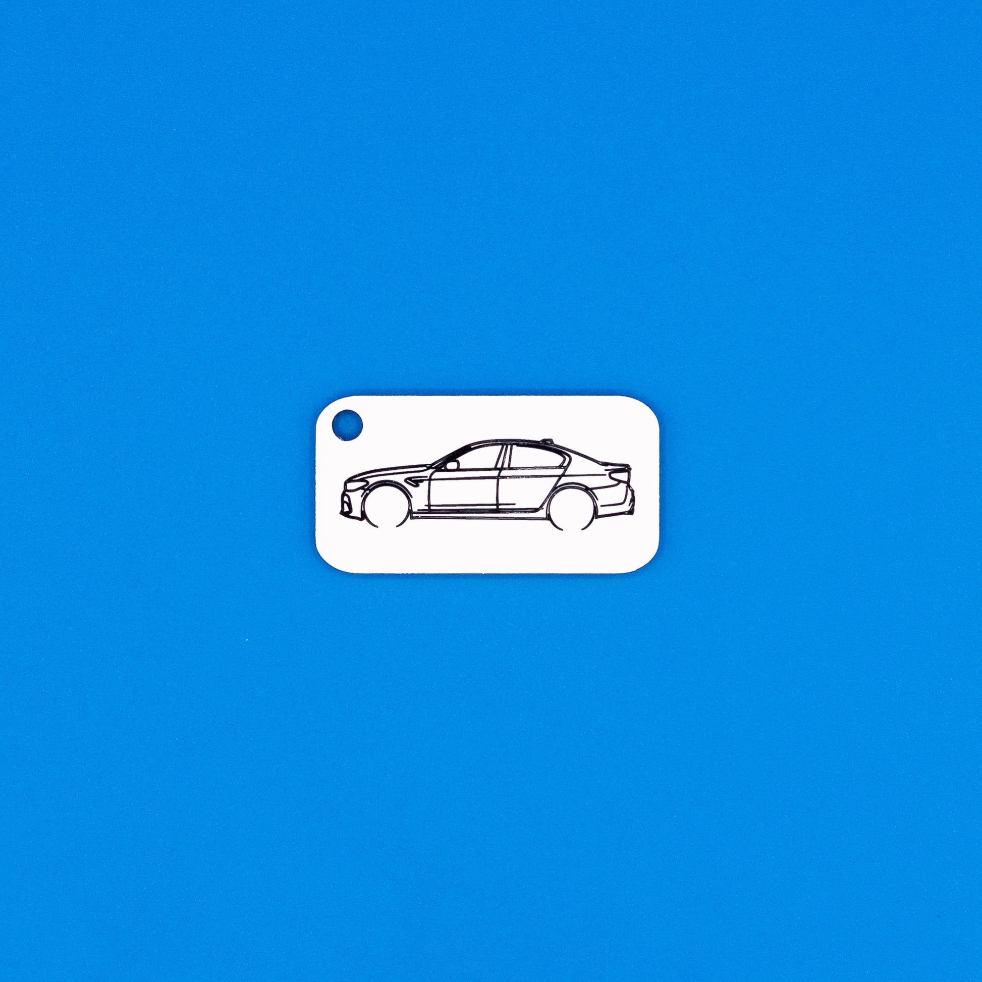 BMW F90 M5 keychain in white on a blue background