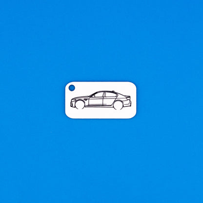 BMW F90 M5 keychain in white on a blue background