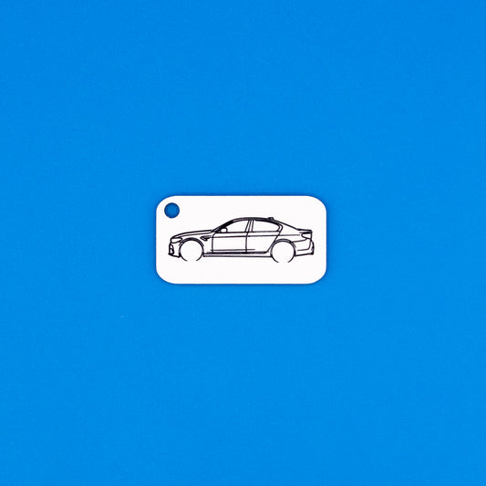 BMW F90 M5 keychain in white on a blue background