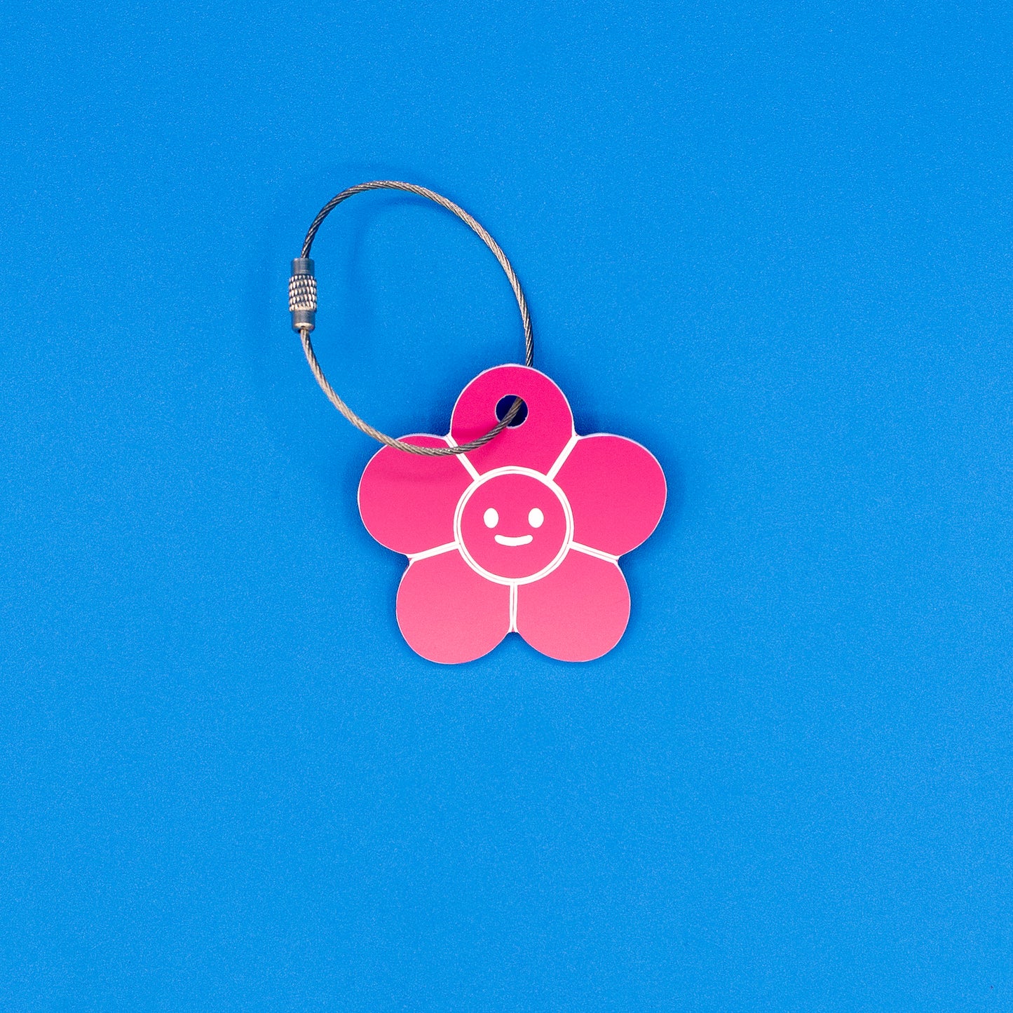 Pink flower-shaped tag with a smiley face on a blue background