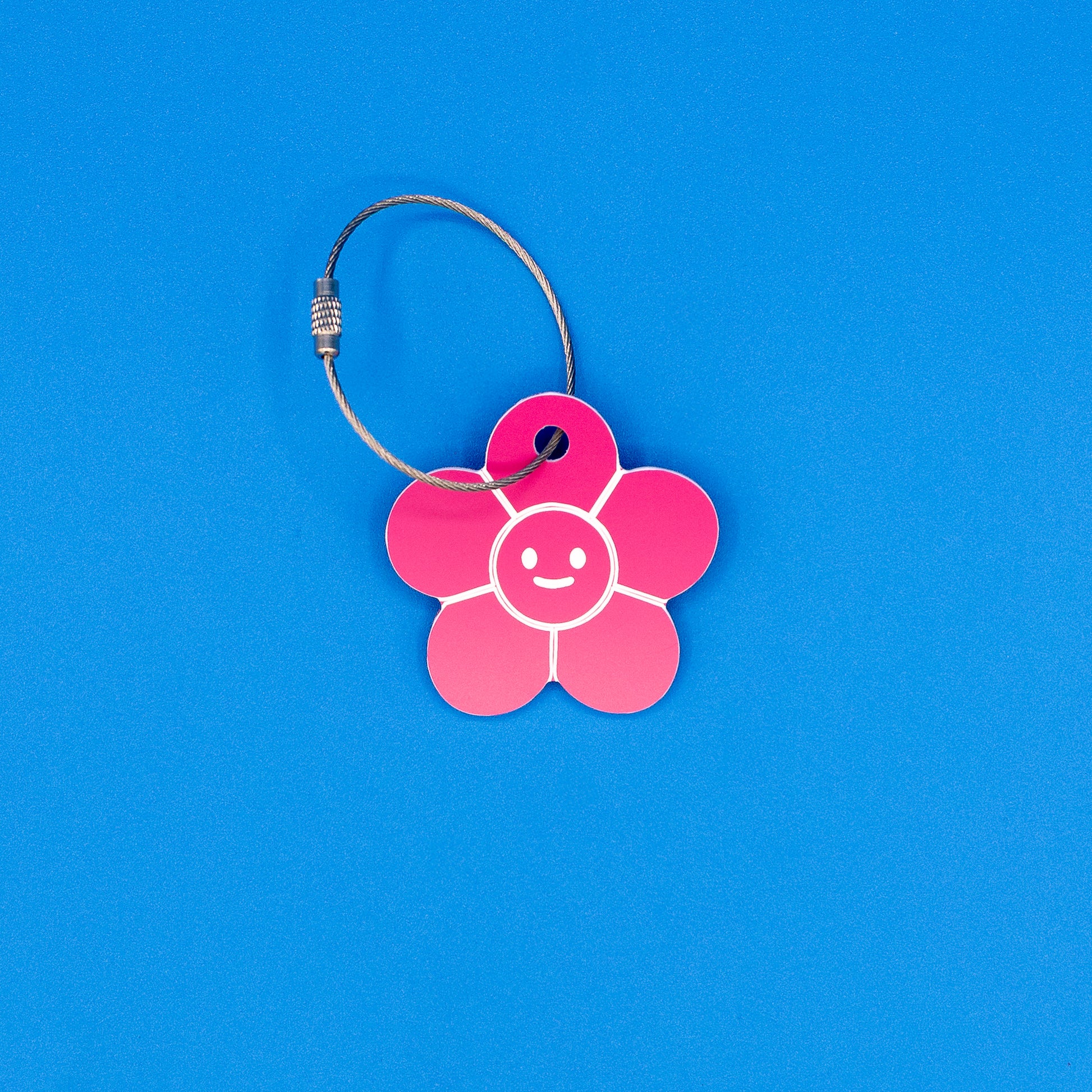 Pink flower-shaped tag with a smiley face on a blue background