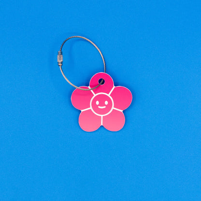 Pink flower-shaped tag with a smiley face on a blue background