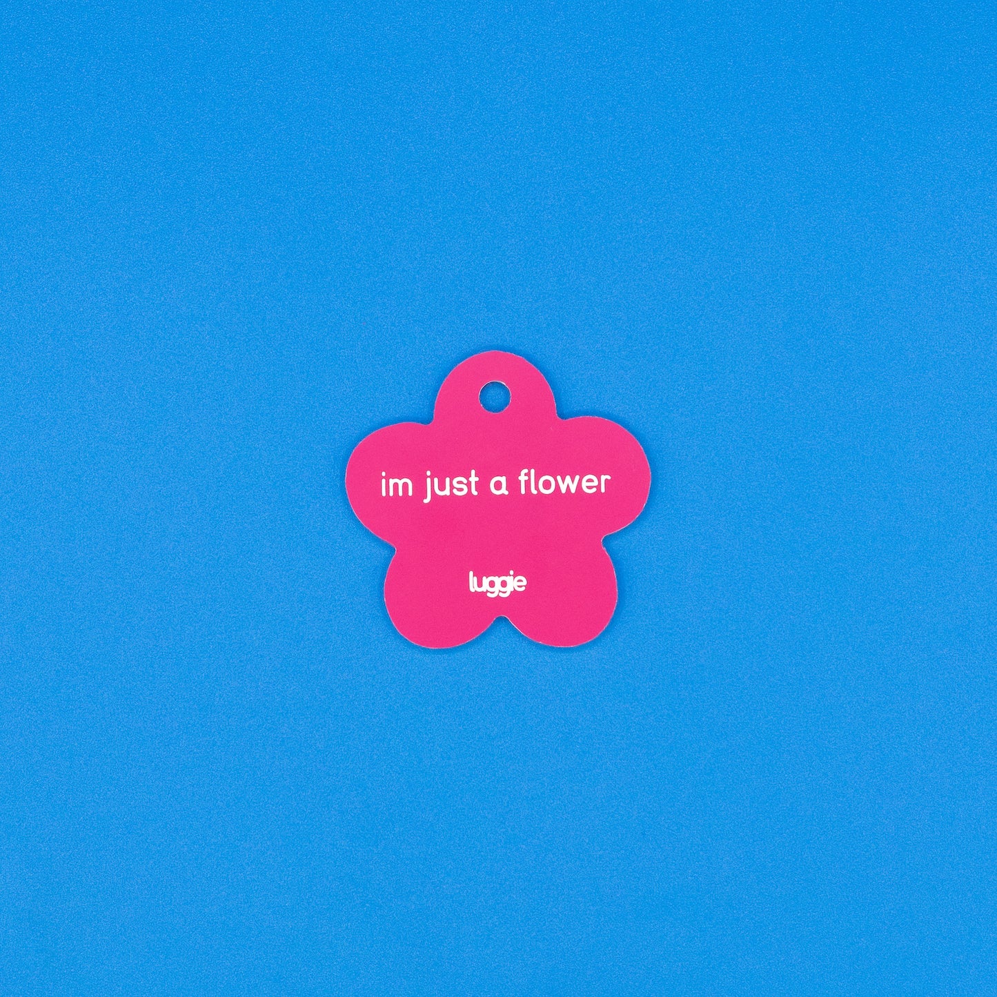 Pink flower-shaped tag with text on a blue background