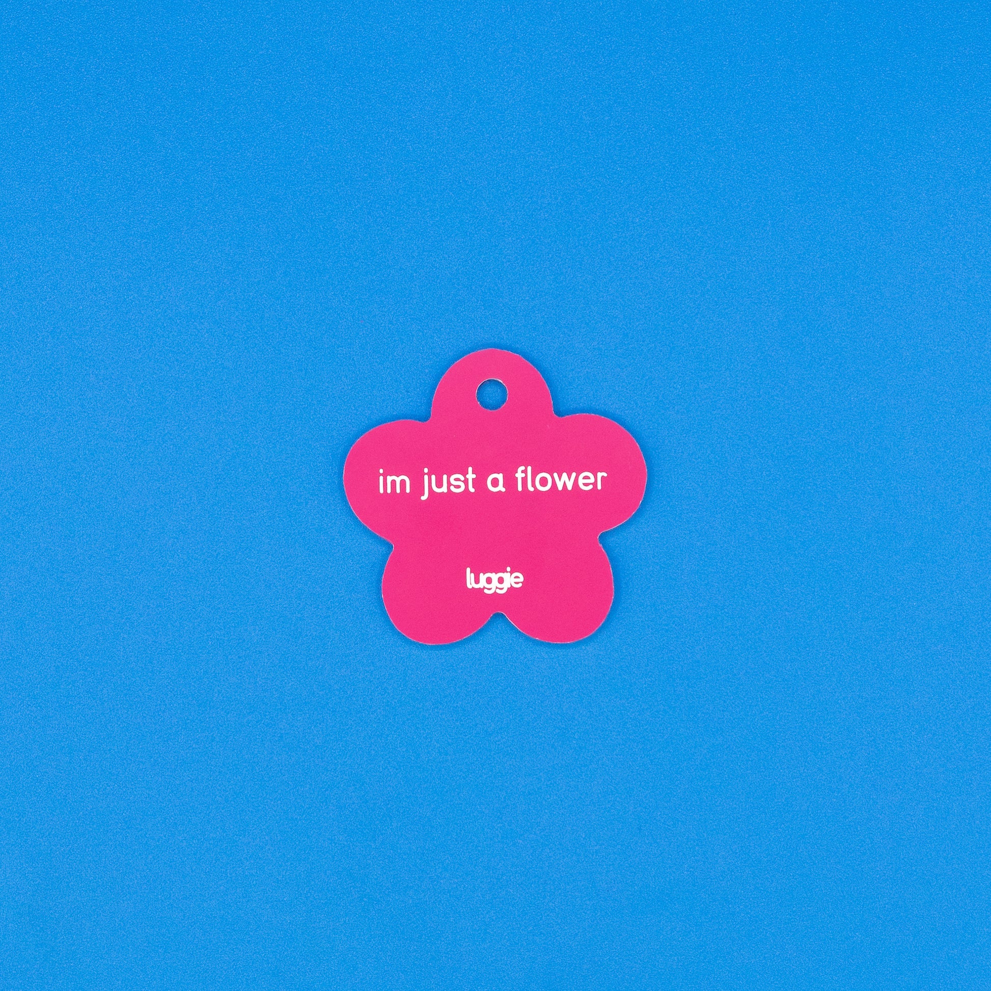 Pink flower-shaped tag with text on a blue background
