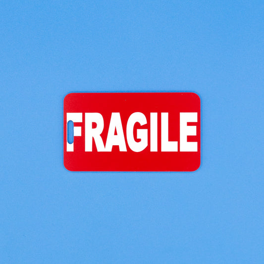Red 'FRAGILE' luggage tag on a blue background