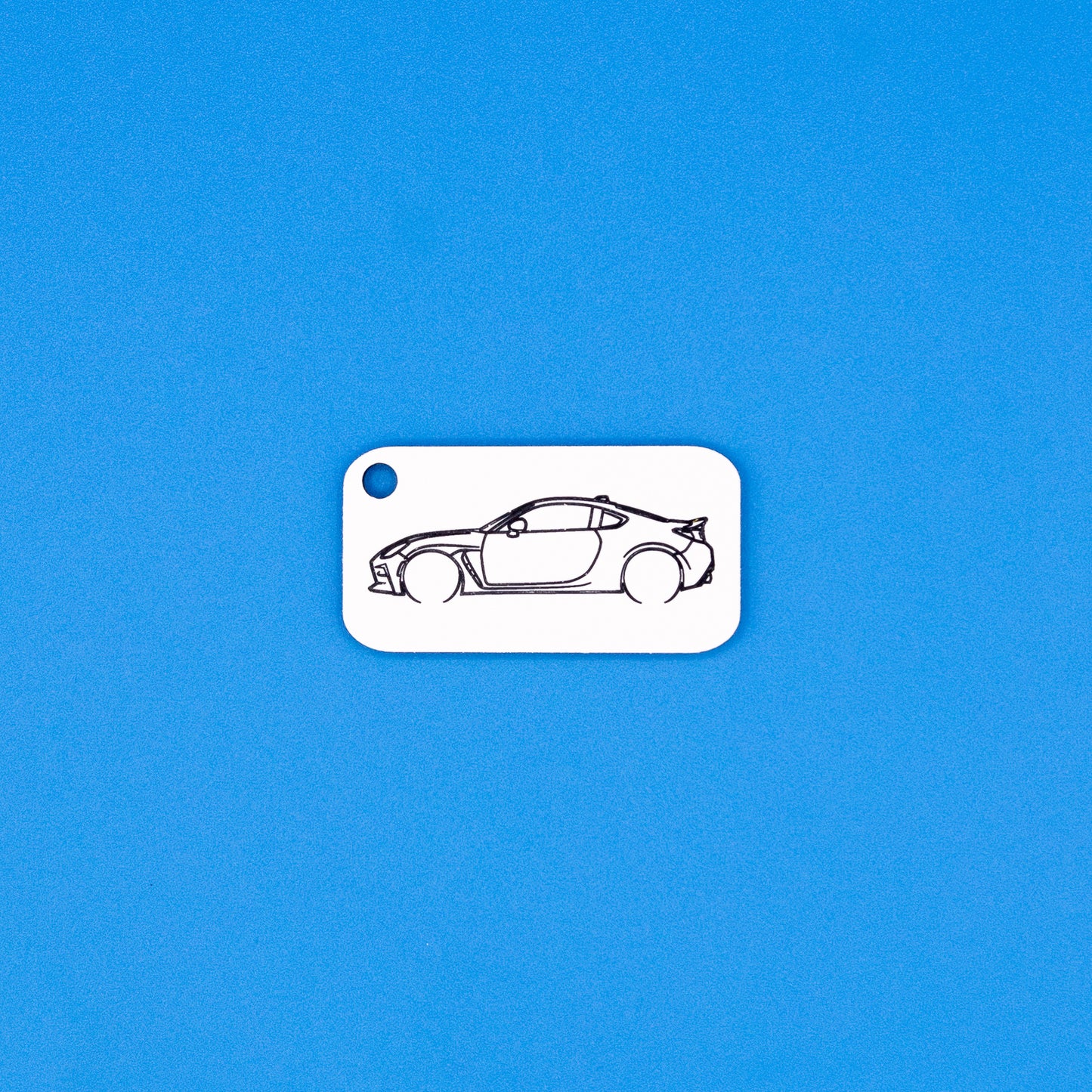 Toyota GR86 car keychain on a blue background