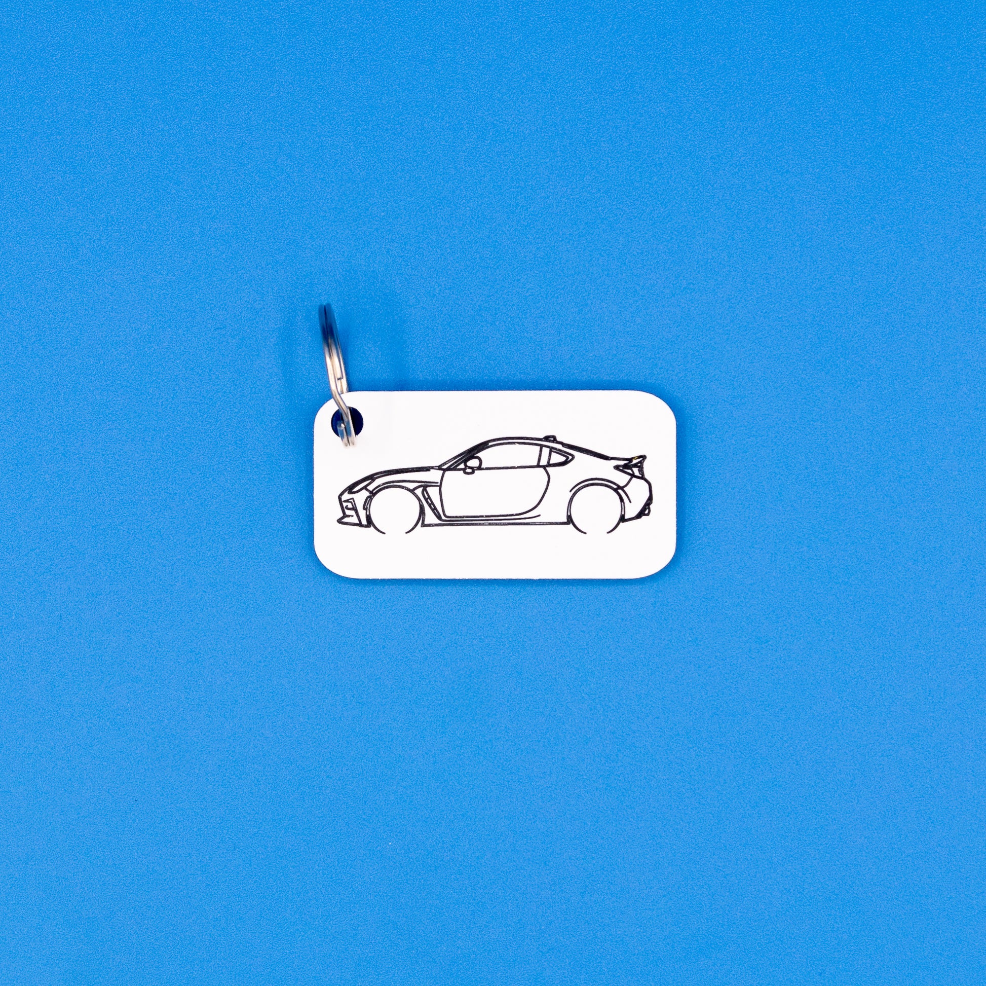 Toyota GR86 Acrylic keychain with key ring on a blue background