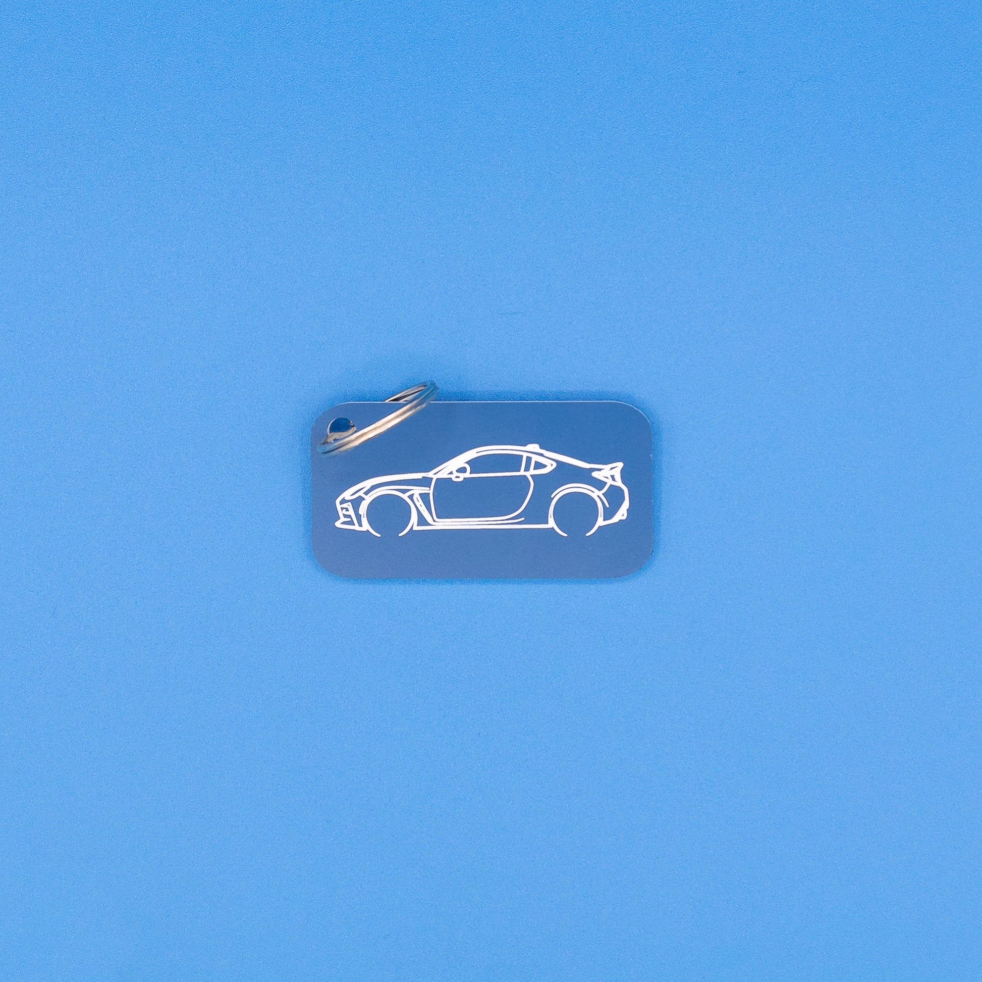 Toyota GR86 Keychain with classic key ring on blue background