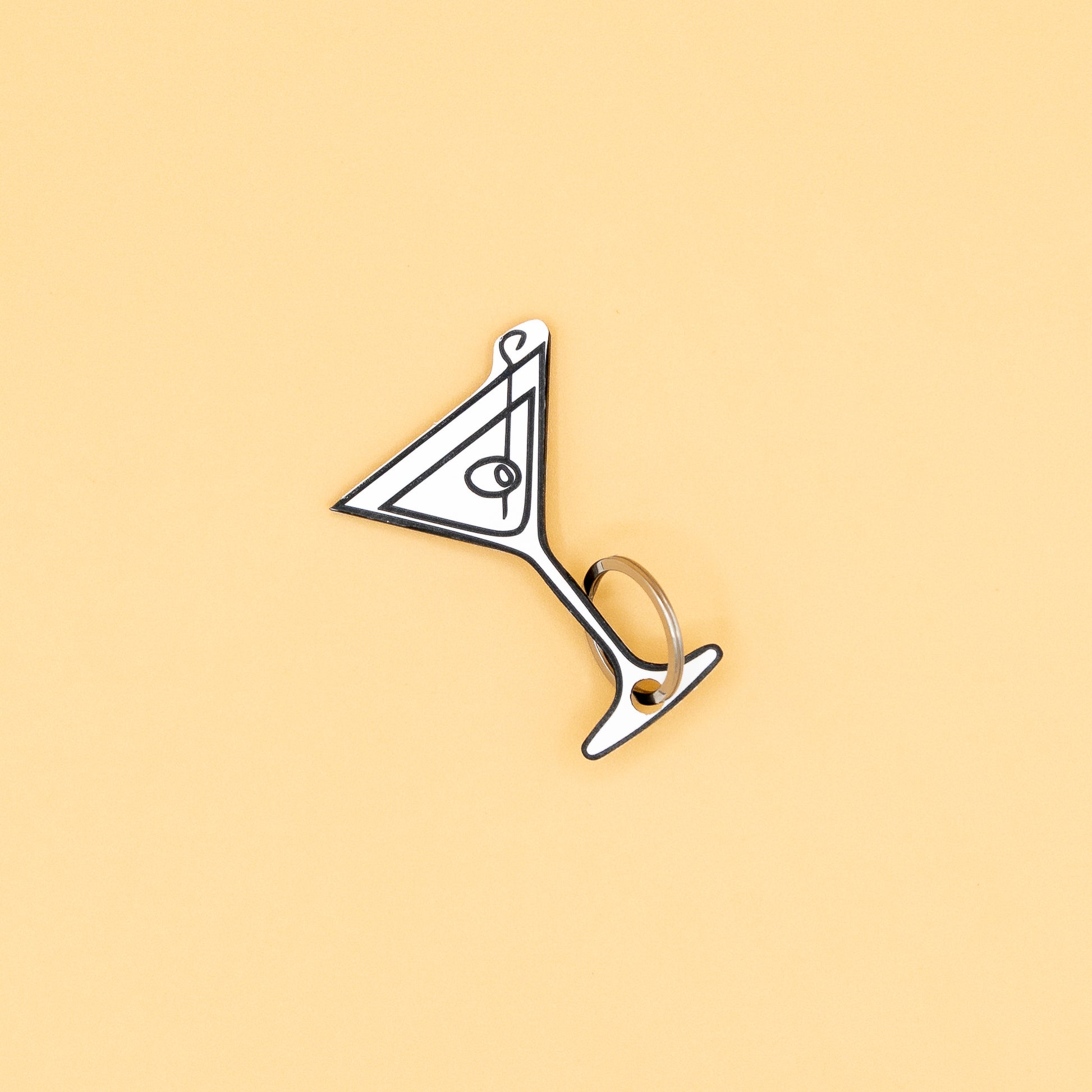 Martini glass-shaped keychain with classic key ring on a beige background