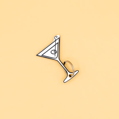 Martini glass-shaped keychain with classic key ring on a beige background