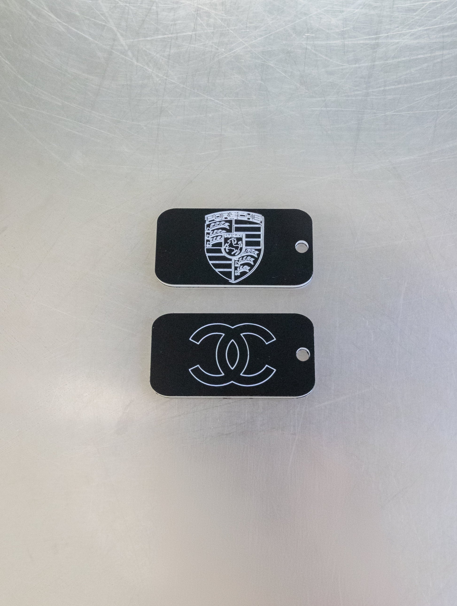 custom key tags with porsche and chanel logos in black